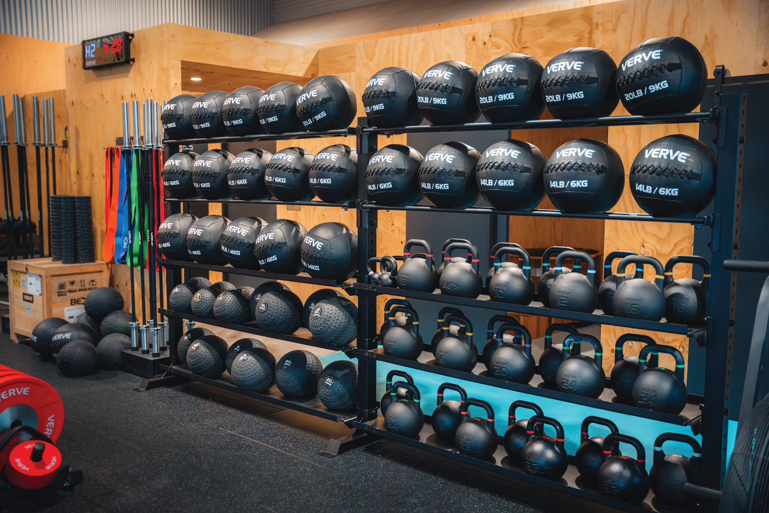 Storage rack of VERVE wall balls, slam balls and kettlebells in a gym showroom