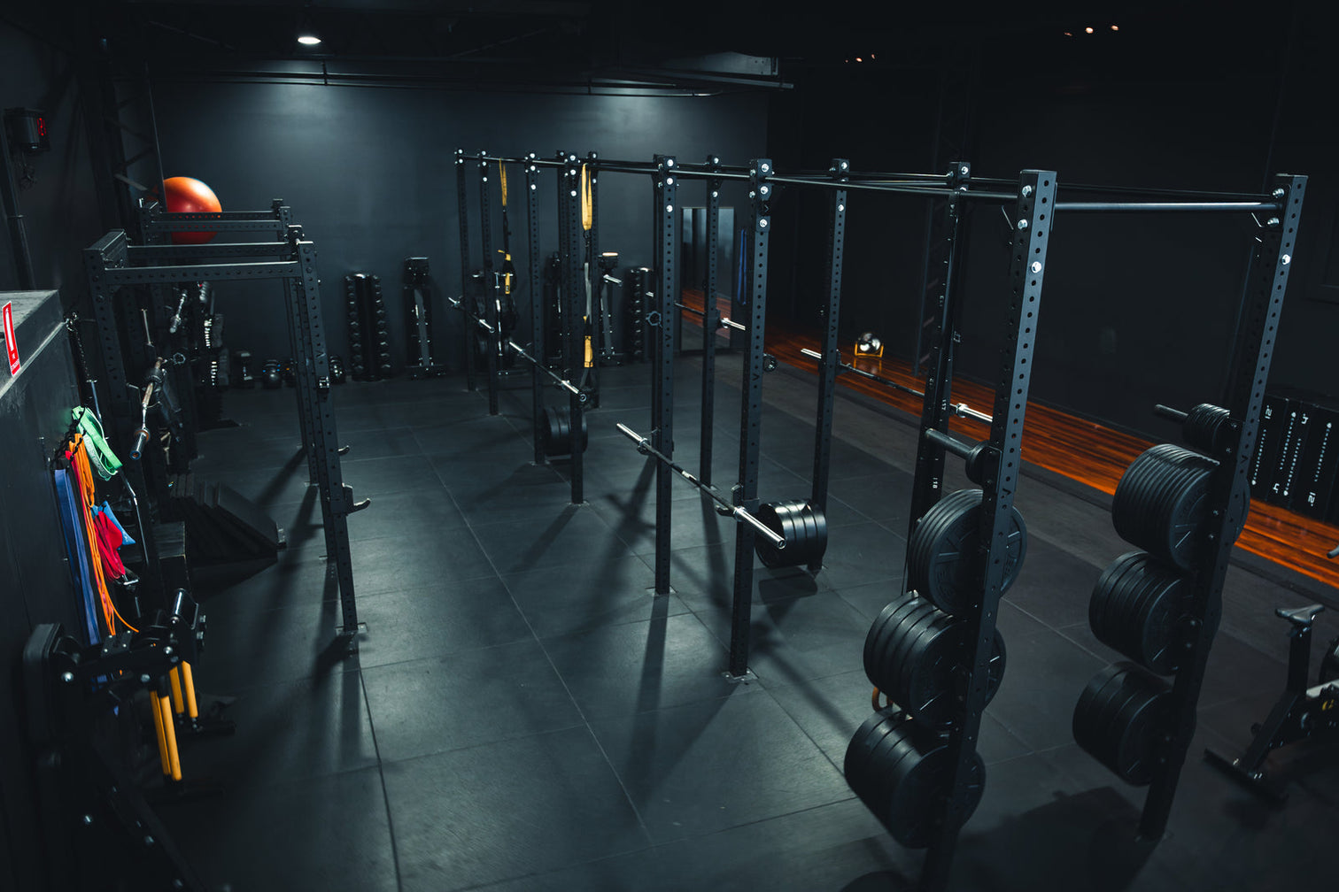 An industrial warehouse space set up as a commercial gym with high ceilings