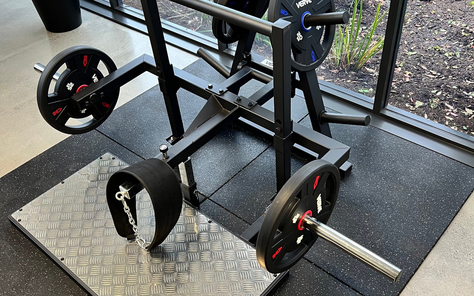 VERVE Hip Belt Squat Machine V3 loaded with plates on a checker-plate platform in the VERVE showroom