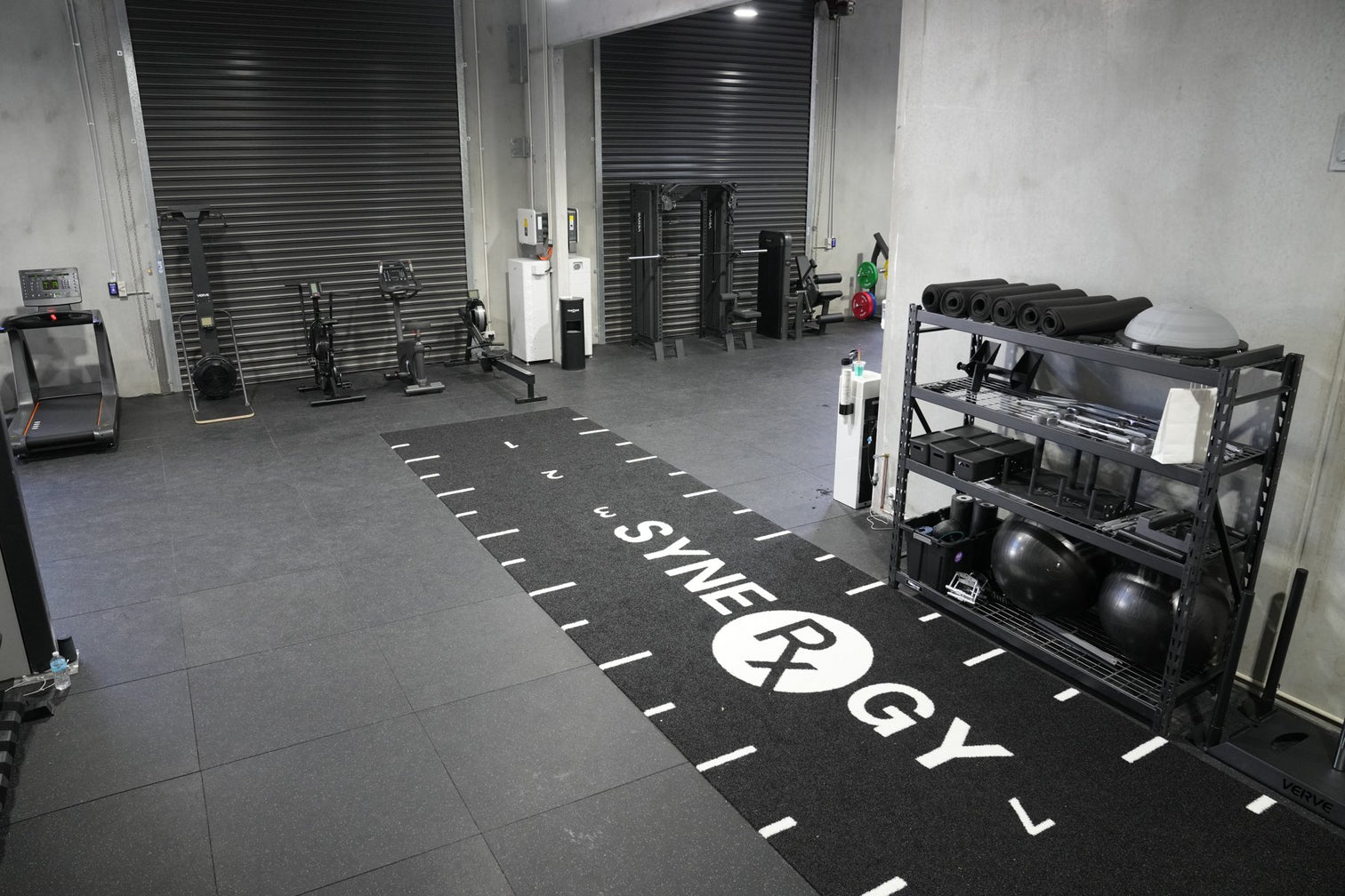 Commercial gym floor with branded rubber flooring and turf track