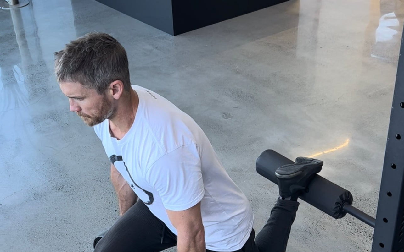 Split squat using a VERVE leg roller attachment on a rack