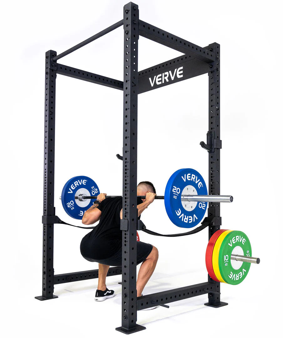 Male athlete performing barbell squats using a Verve squat rack — high-quality power rack with bumper plates for home or gym training.