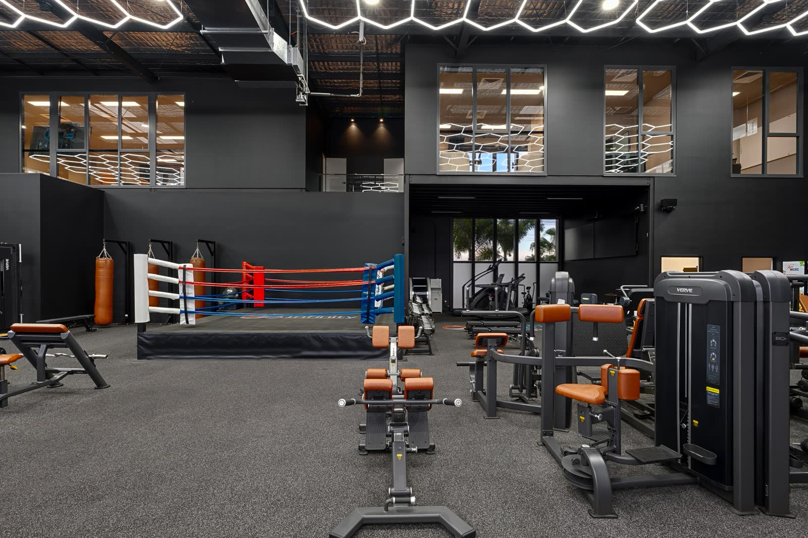 Makoto machines in brown upholstery across the floor, the boxing ring and mezzanine behind